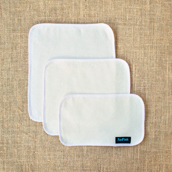 3 unfolded hemp fleece towel inserts showing the sizes Light, Medium and Heavy